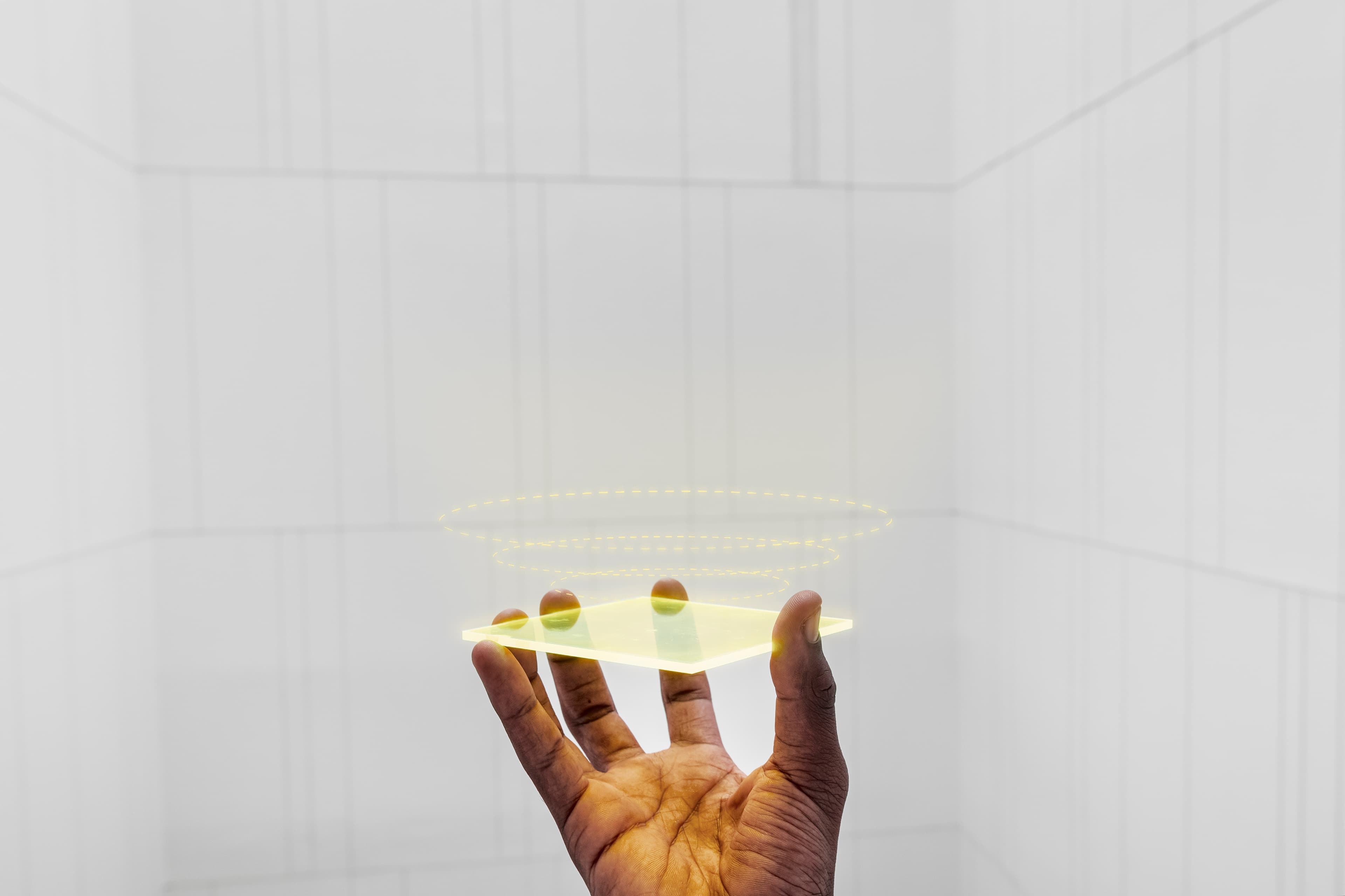 Une main tenant une plaque de lumière dorée en lévitation, symbole de la donnée façonnée par ceux qui la produisent.